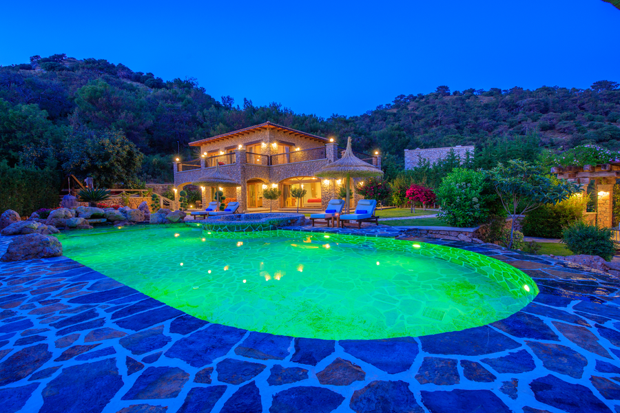 Night-lit stone villa with glowing pool at Villa Elmalı