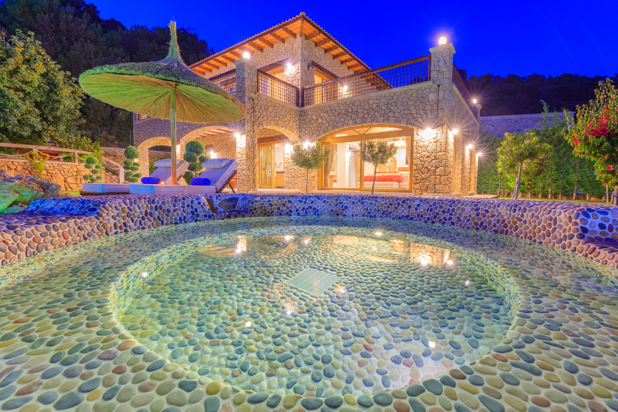 Night-lit stone jacuzzi and terrace view at Villa Elmalı