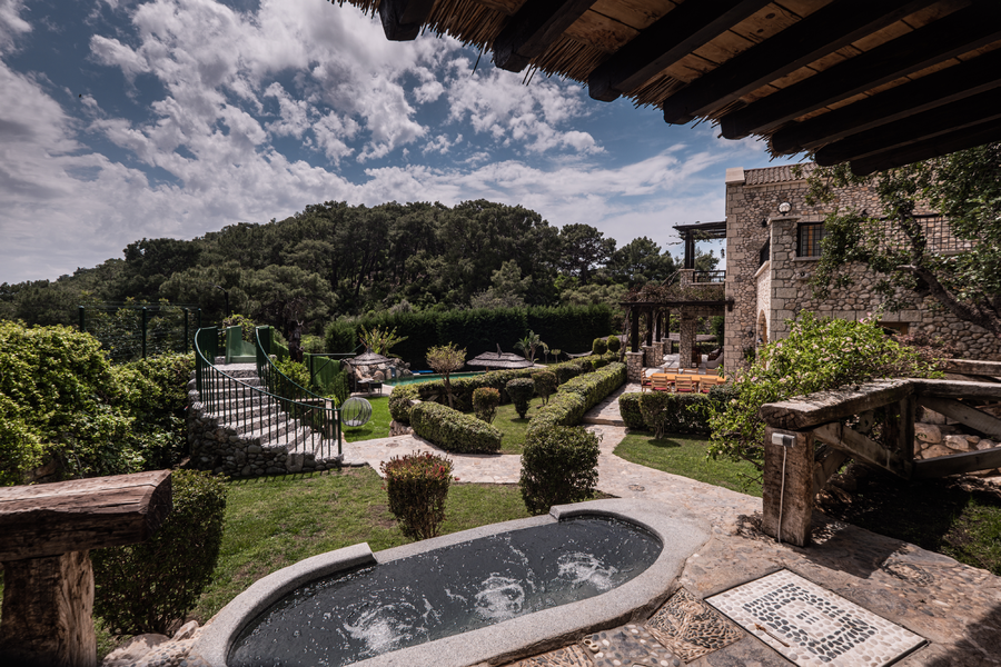 Garden terrace with stone jacuzzi overlooking lush Mediterranean forest