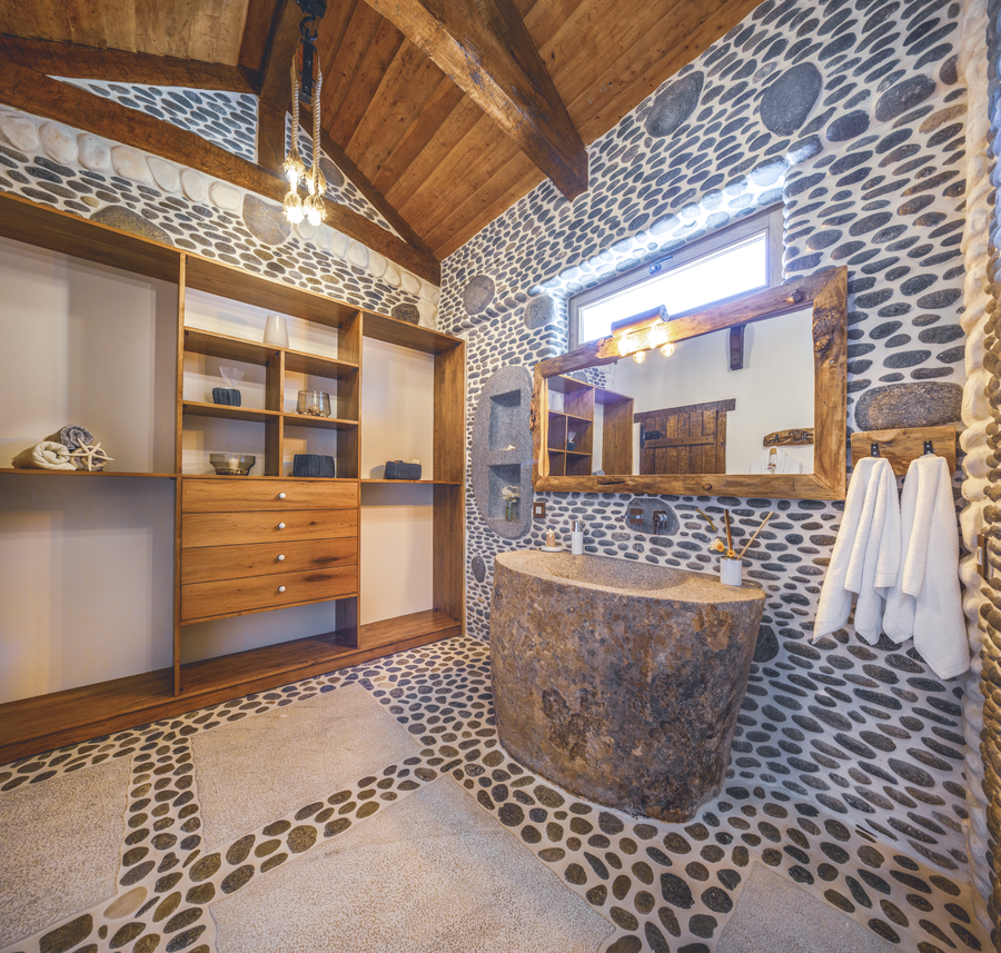 Panoramic stone-textured bathroom with handcrafted wooden elements and natural light