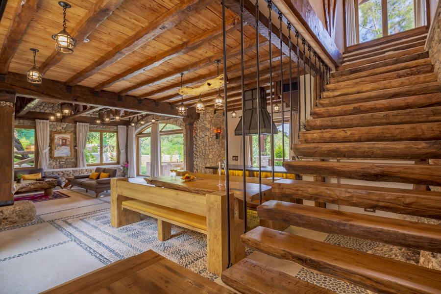 Rustic wooden staircase overlooking open-plan dining and living spaces