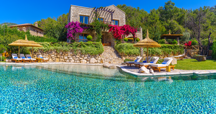 Stone villa overlooking a tranquil private pool on a forested peninsula
