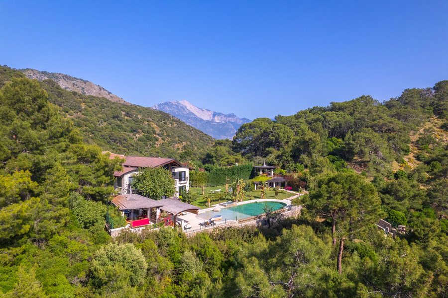 Aerial estate view of Villa Gökçe framed by forested hills and Mediterranean mountains