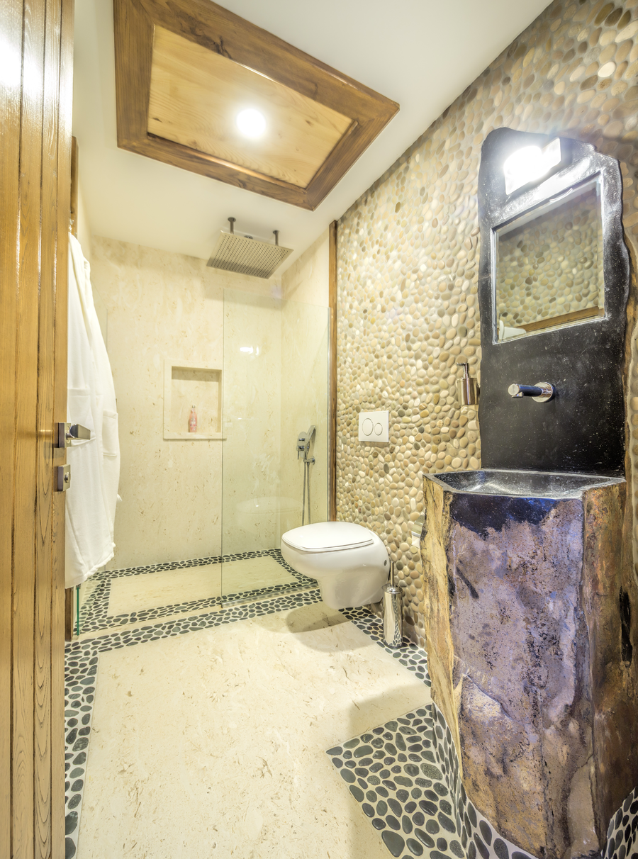 Natural stone bathroom with textured walls and walk-in shower
