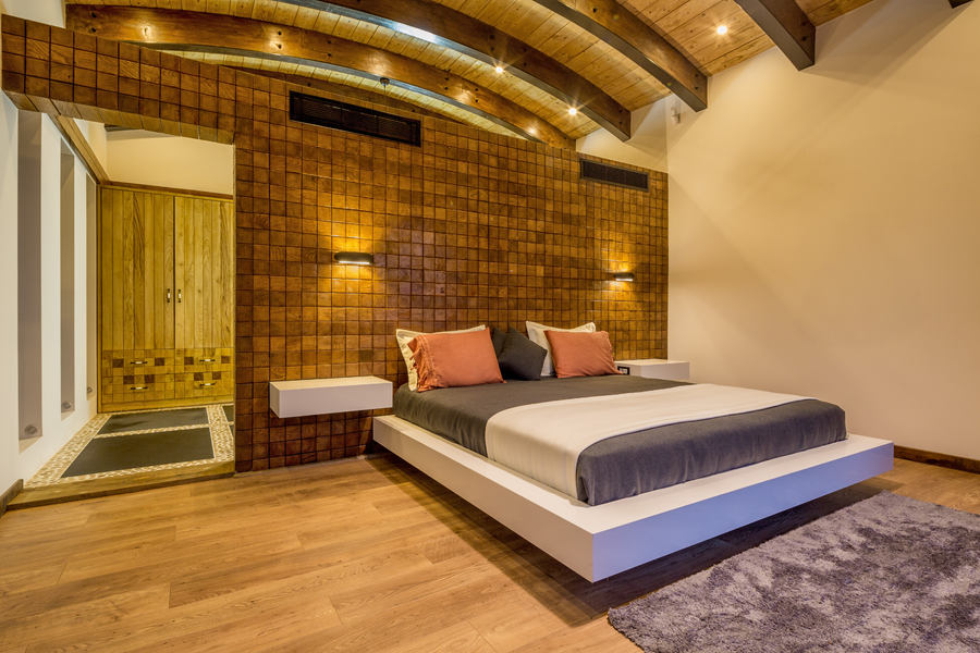 Bedroom with textured wood wall and modern low-profile platform bed