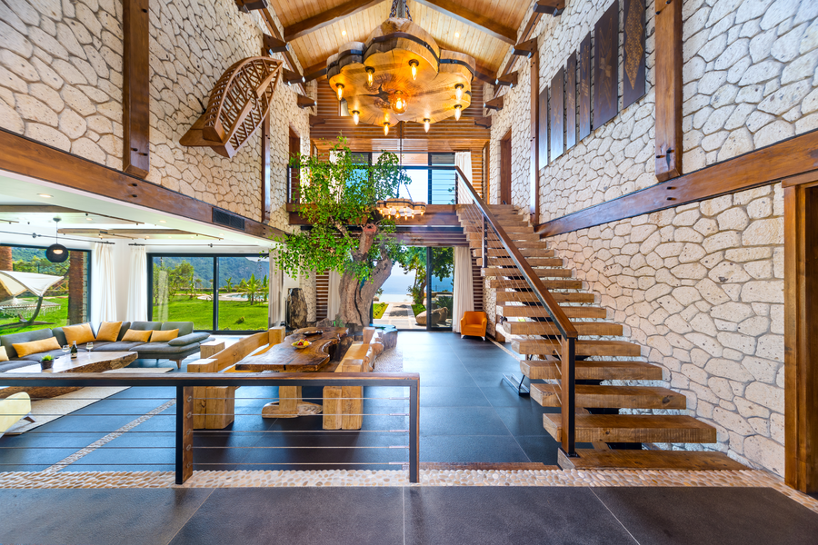 Double-height stone living space opening to gardens and the sea