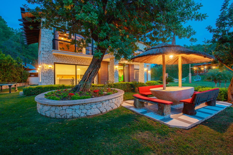Garden dining pavilion with stone seating and evening ambient light