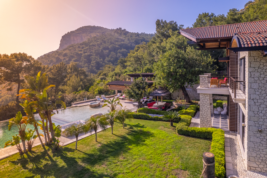 Golden hour hilltop view of Villa Gökçe with stone pool and lush gardens