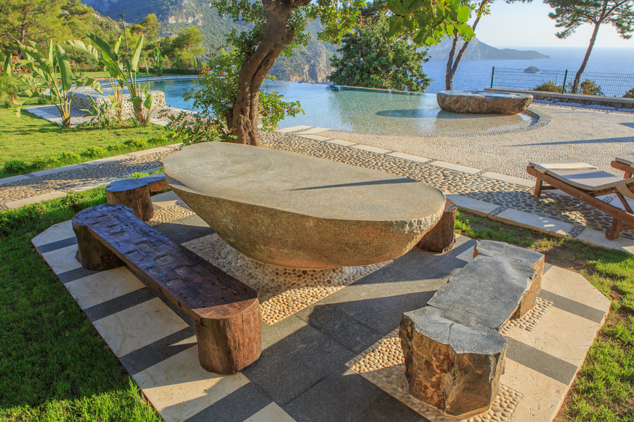Handcrafted stone table overlooking infinity pool and Mediterranean bay