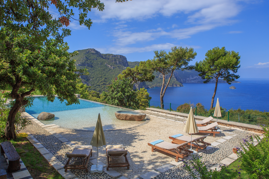 Infinity pool terrace overlooking deep blue Mediterranean cliffs