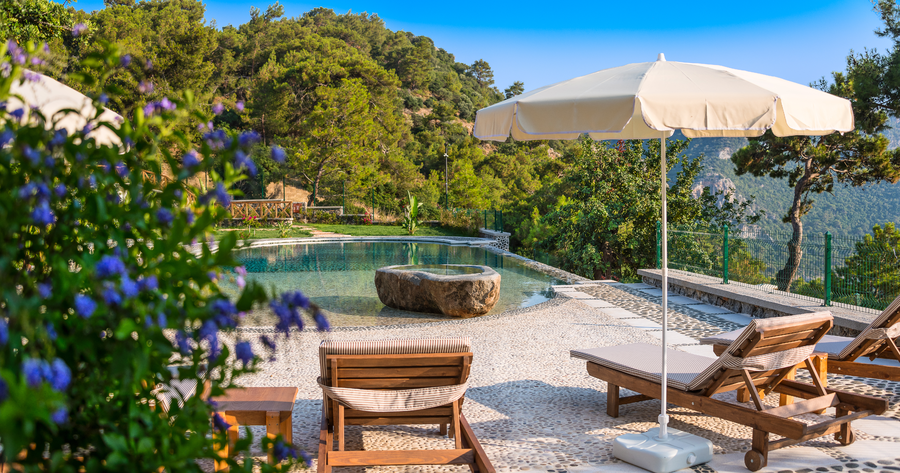 Infinity pool terrace surrounded by gardens and forested hills