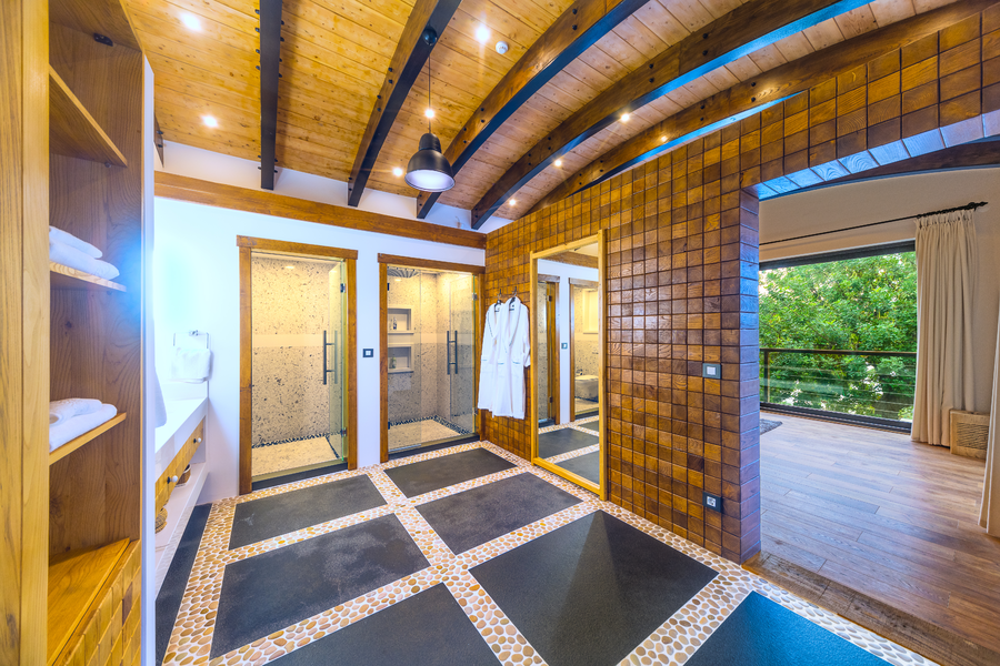 Spacious master bathroom with double walk-in showers and wooden vaulted ceiling