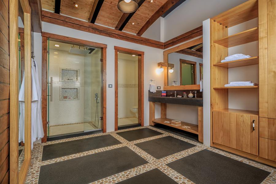 Master bathroom with timber beams, stone accents and walk-in glass shower
