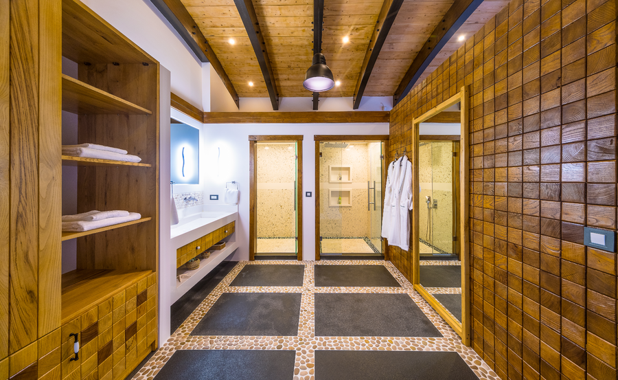 Master bathroom with wooden accent walls and dual walk-in showers