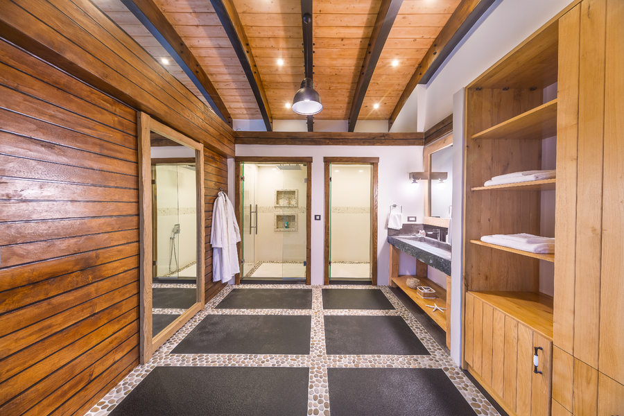 Master bathroom with wooden walls and dual walk-in showers