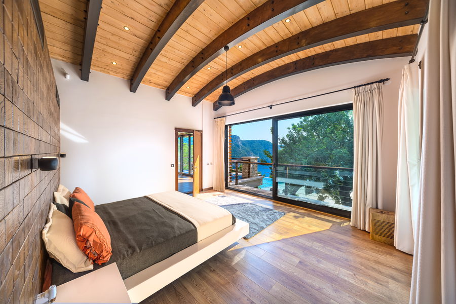 Master bedroom with arched timber ceiling and sea-facing terrace