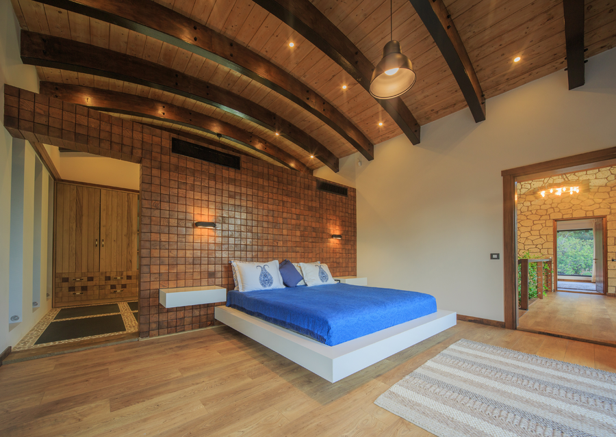 Master bedroom with wooden ceiling beams and blue bedding