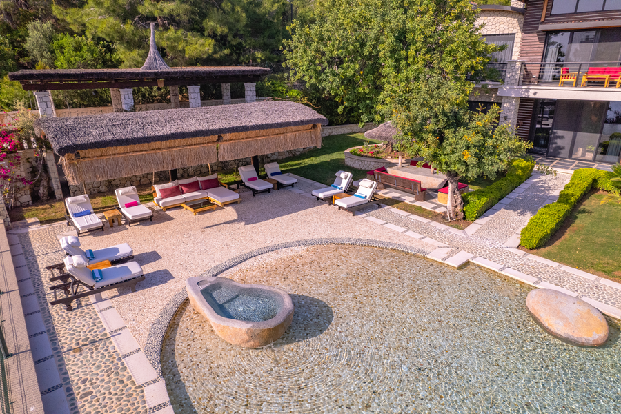 Drone view of Villa Gökçe poolside sunbeds and shallow stone pool