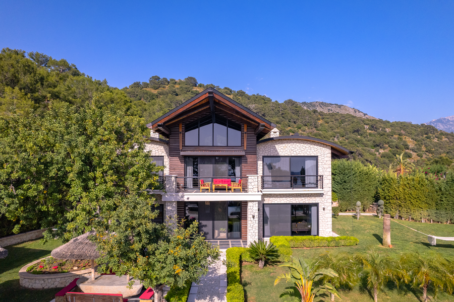 Symmetric front view of Villa Gökçe with stone façade and mountain backdrop