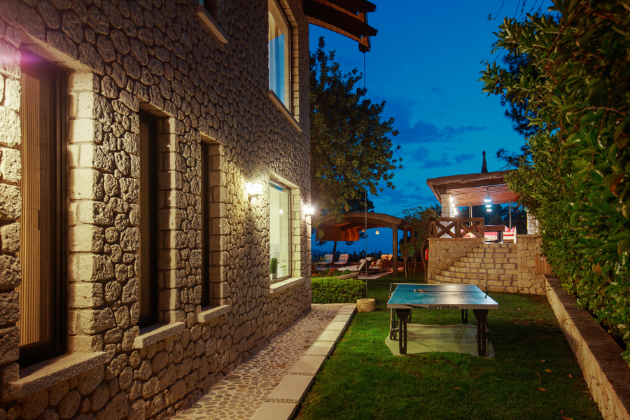 Stone-facade villa with night-lit recreation corner overlooking the gardens