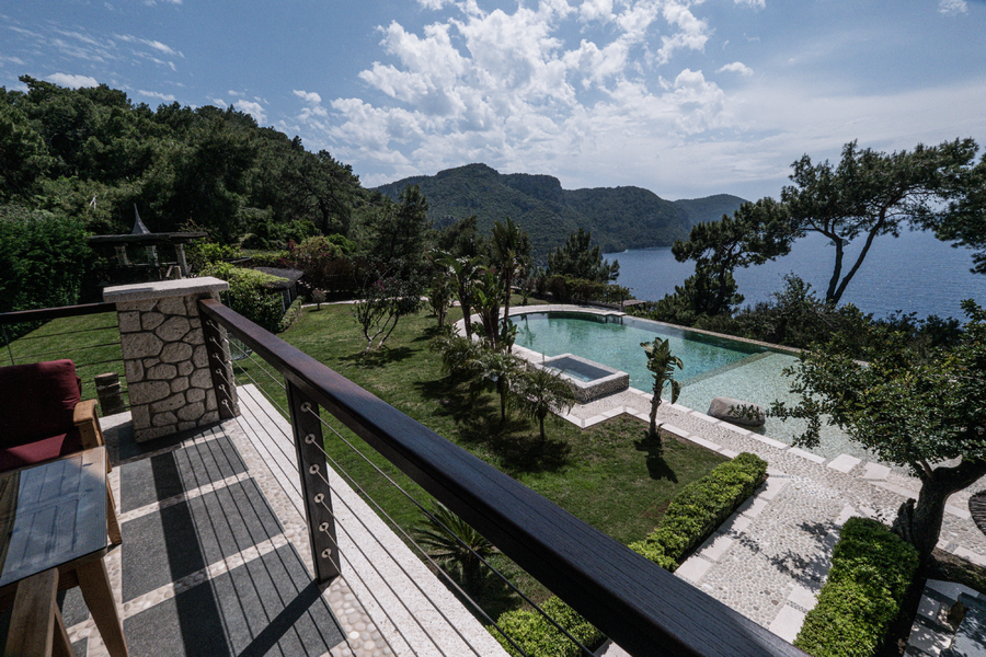 Terrace viewpoint overlooking private pool, gardens and a secluded Mediterranean bay