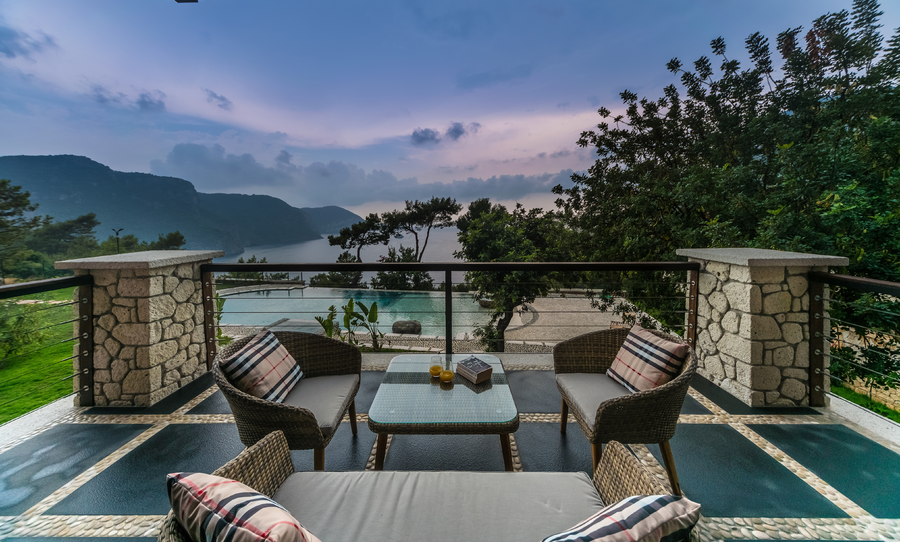 Terrace seating with panoramic sea and mountain views at sunset