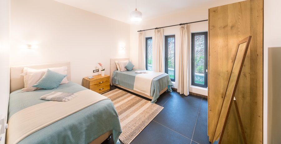 Twin bedroom with soft pastel design and bright garden-facing windows