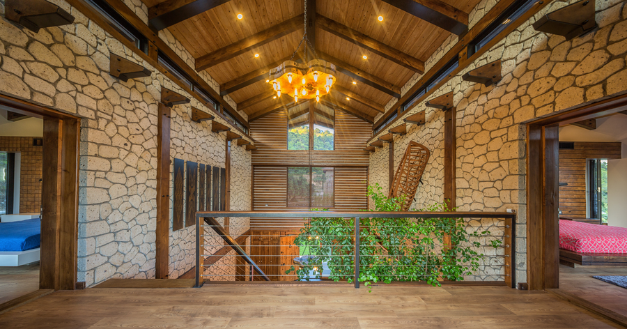 Upper floor hallway with stone walls, wooden beams and mezzanine view